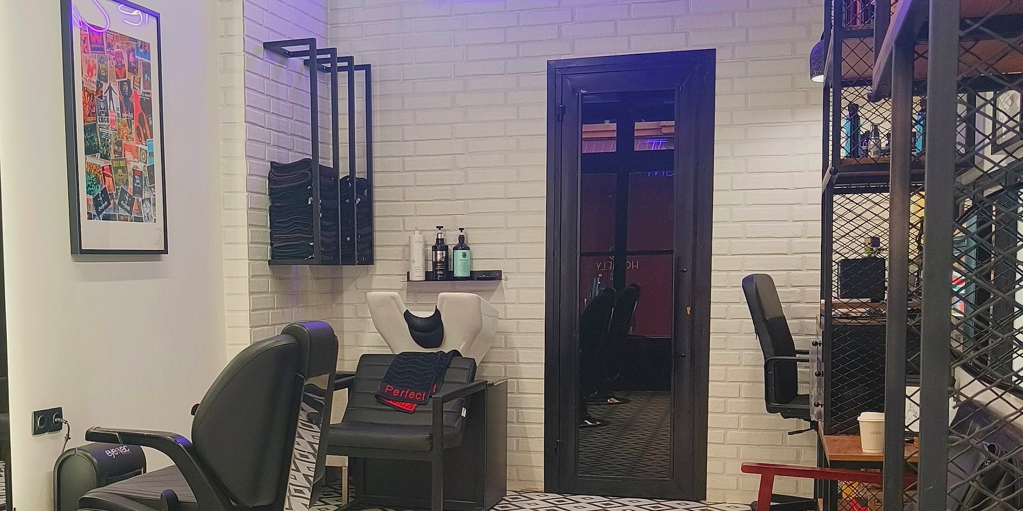Το εσωτερικό του THE CUTMAN με το μοβ neon, το λευκό τούβλο και τα ασπρόμαυρα γεωμετρικά πλακάκια